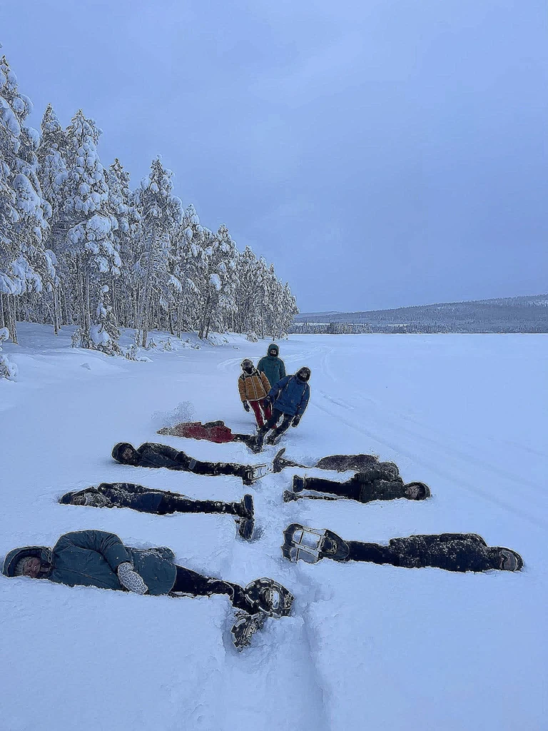 jeux d'enfants dans la neige pour les participants au voyage en laponie suédoise